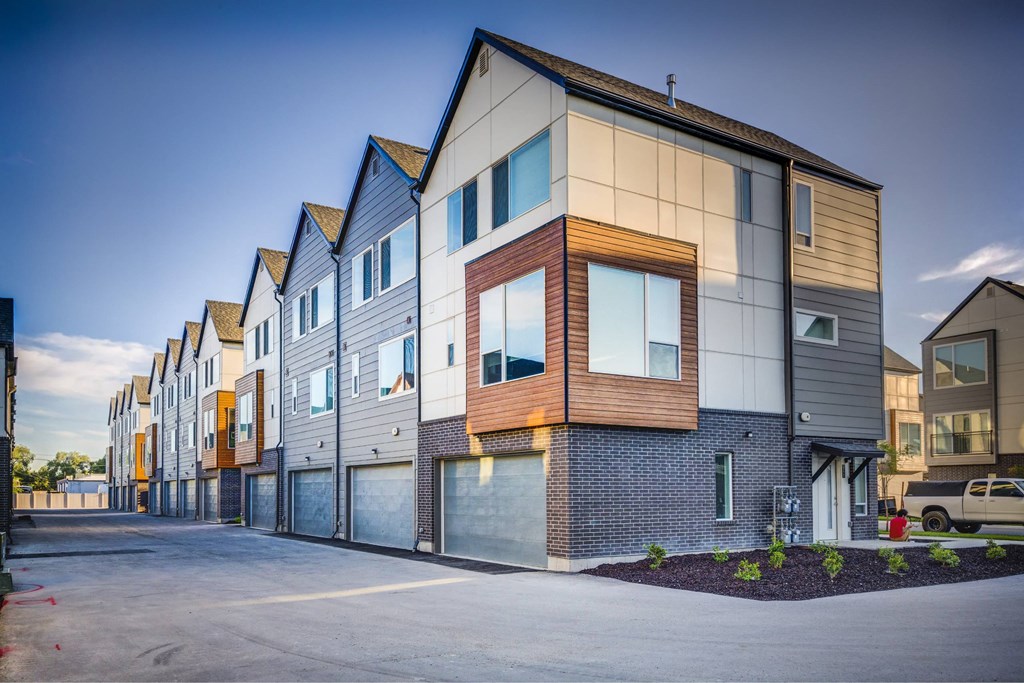 a row of new townhouses with a street in front of them