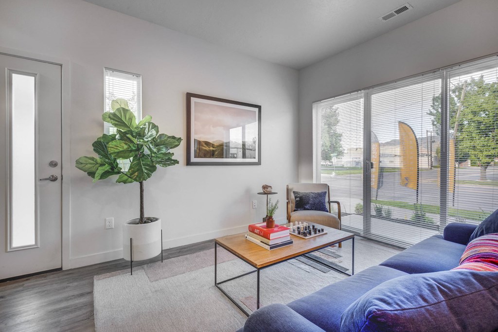 a living room with a blue couch and a table with a potted plant