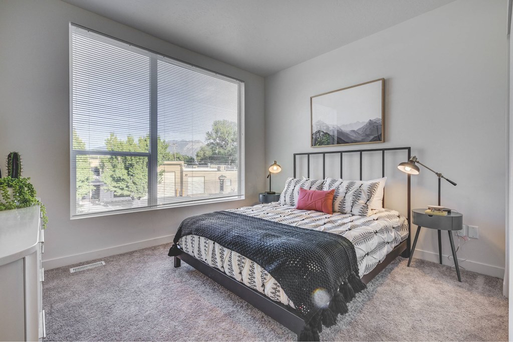 a bedroom with a bed and a large window