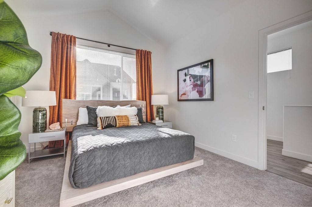 a bedroom with a bed and a large window