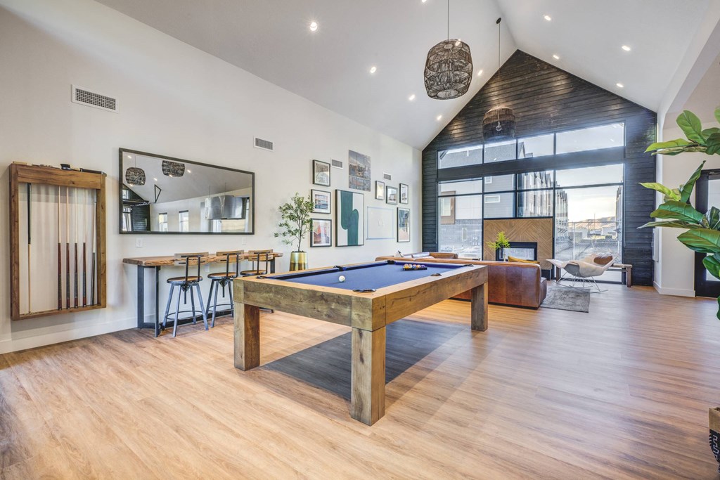 a pool table in a living room with a bar and a fireplace