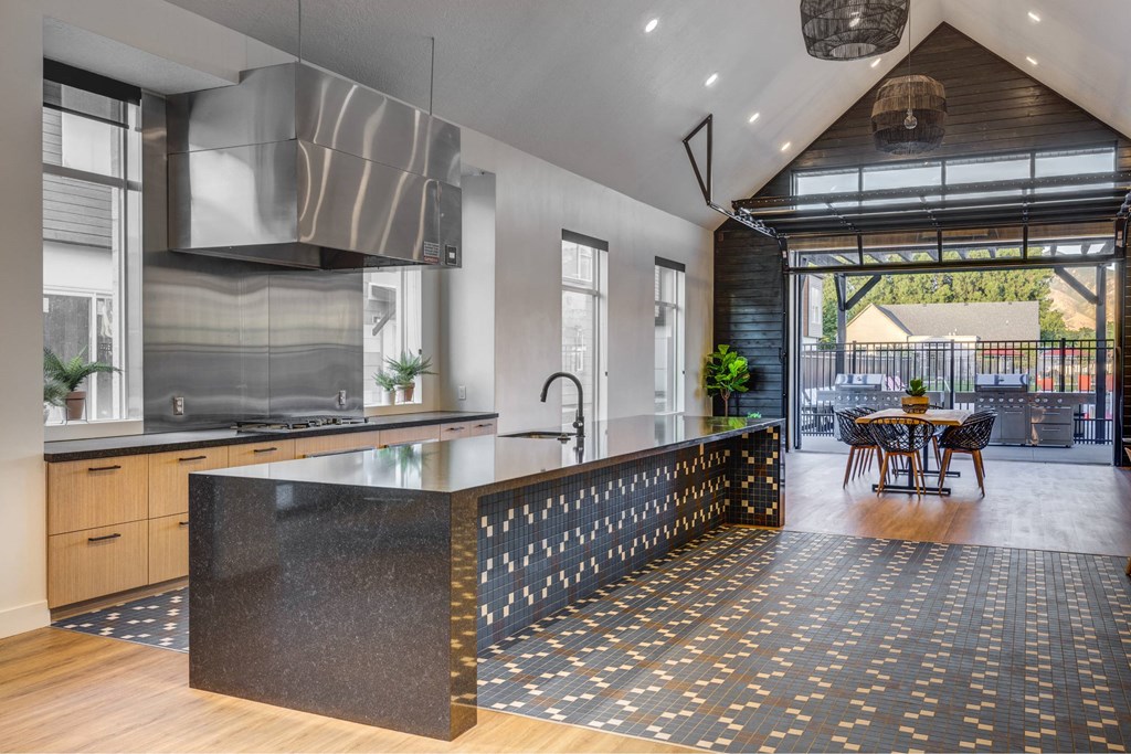 a kitchen with a large island and a dining area with a table and chairs