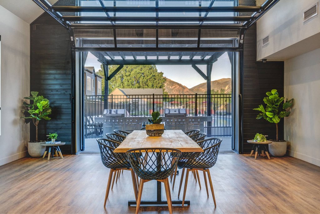 a dining room with a table and chairs and a balcony