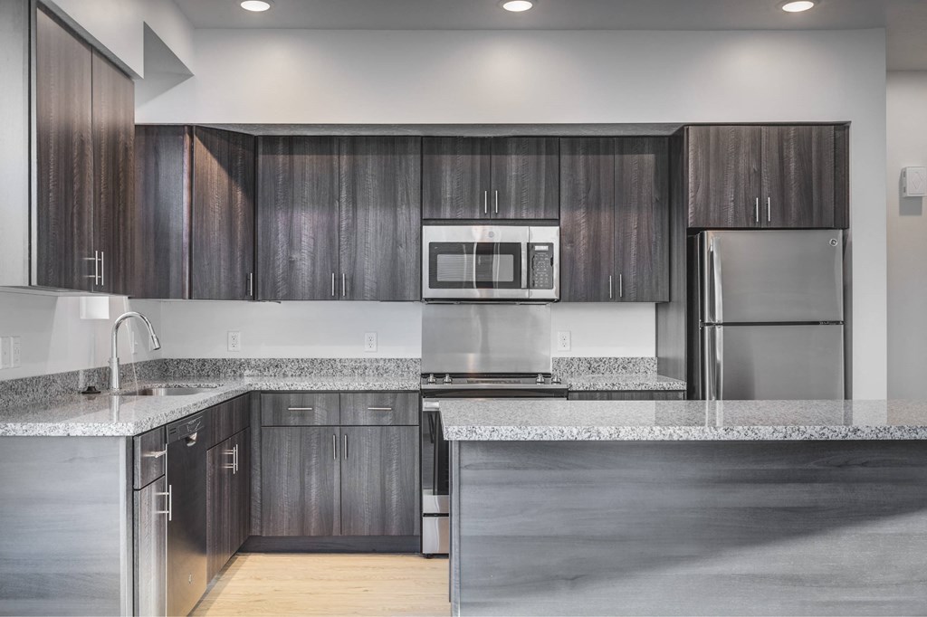 a kitchen with stainless steel appliances and marble counter tops