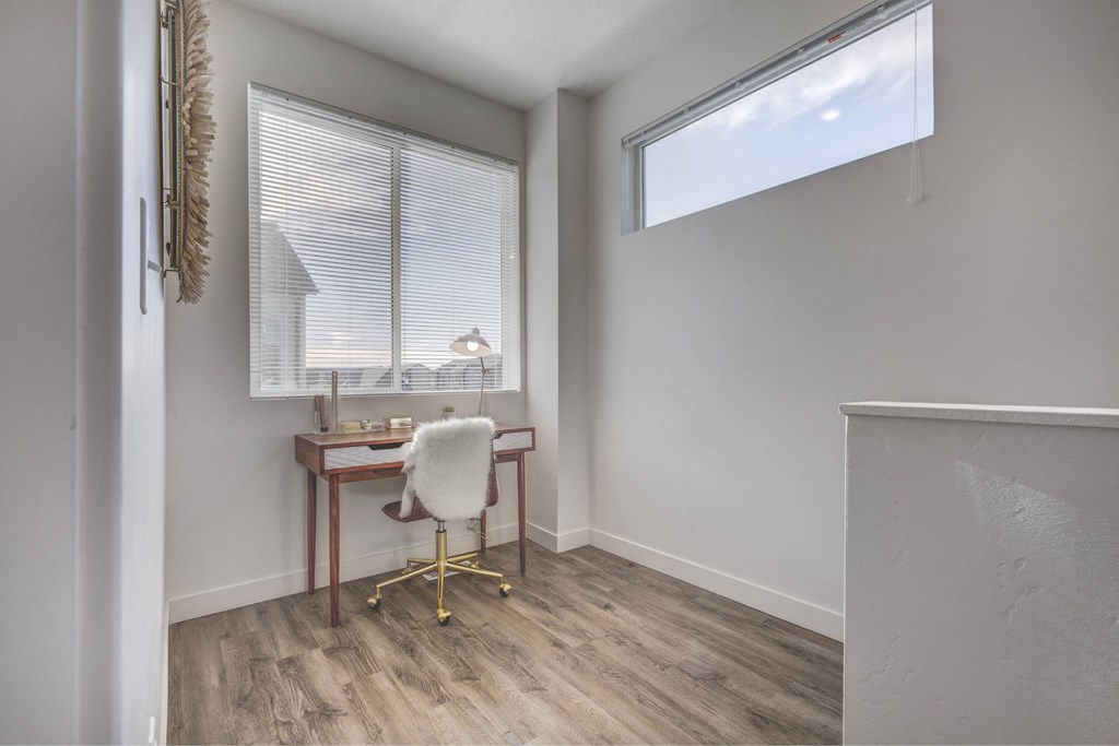 an office space with a desk and a window