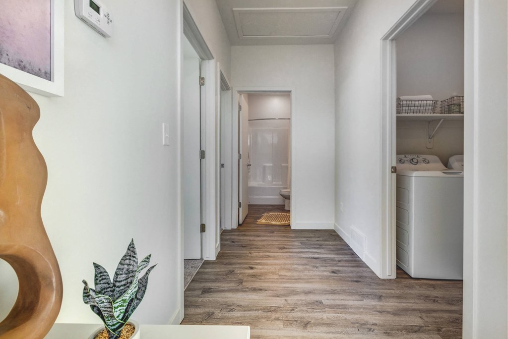 a long hallway with a guitar and a sink and a laundry room