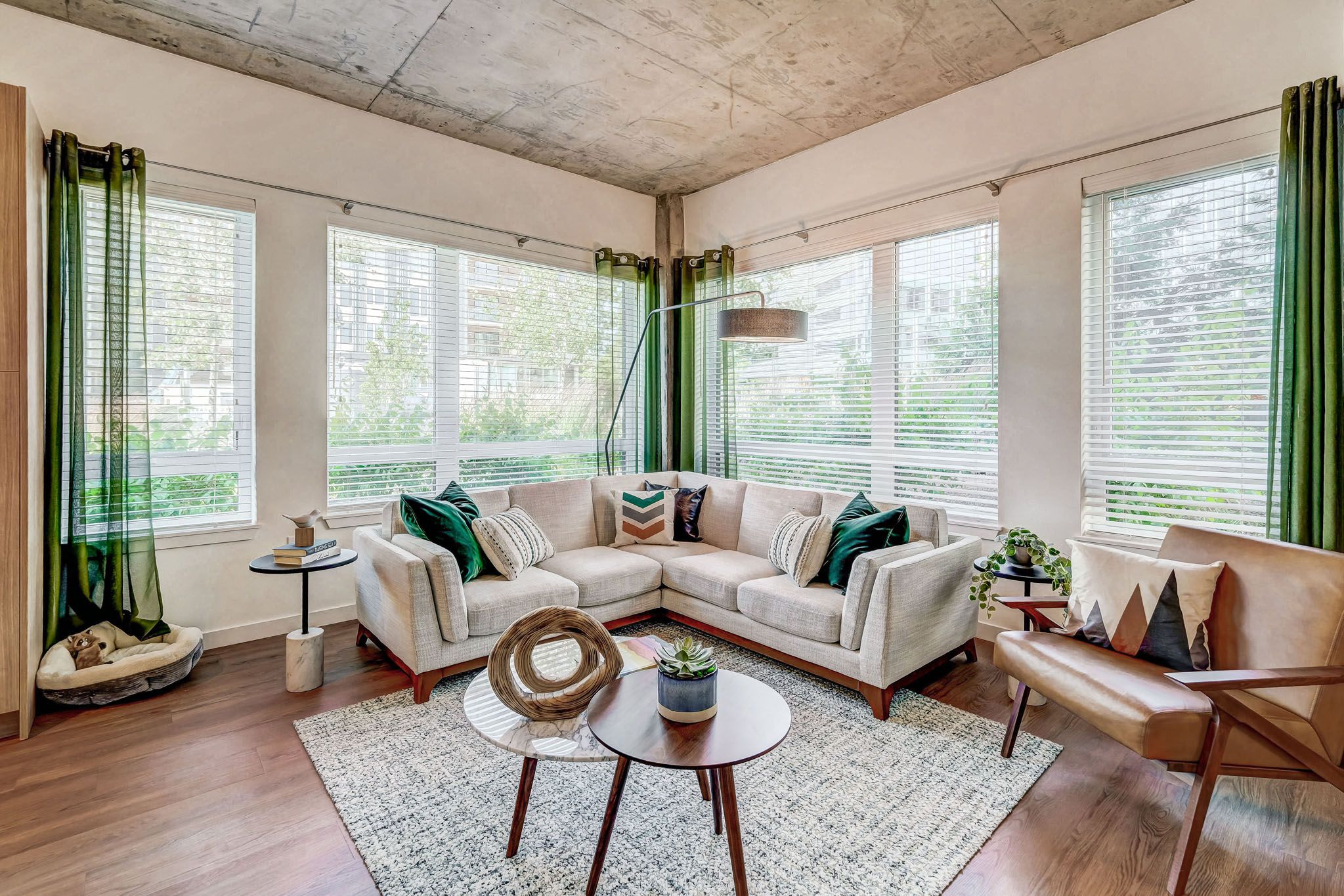 A living room with a white couch and green curtains.