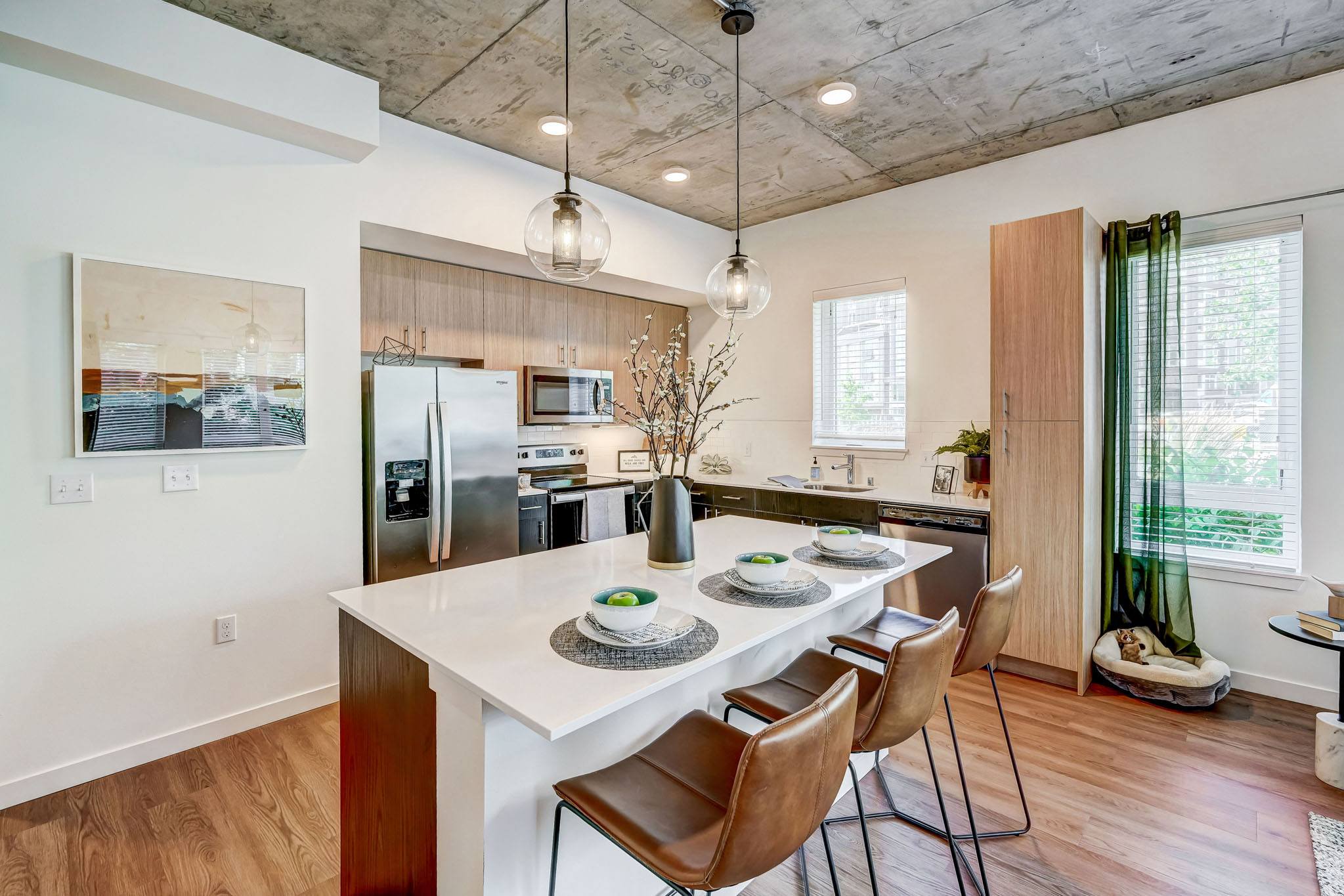 A kitchen with a white table and brown chairs.