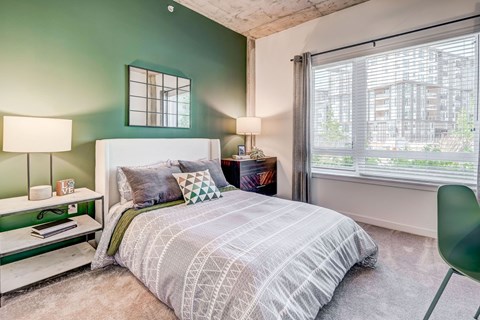 a bedroom with a bed and two windows