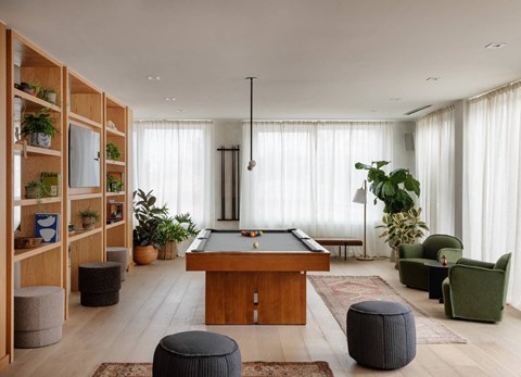 A room with a pool table and a green chair.