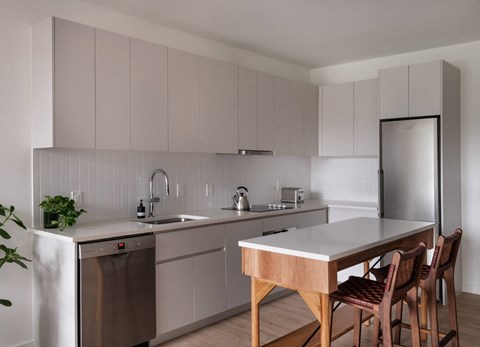 A modern kitchen with a wooden table and chairs.