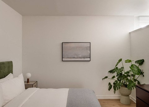 a bedroom with a bed and a painting on the wall