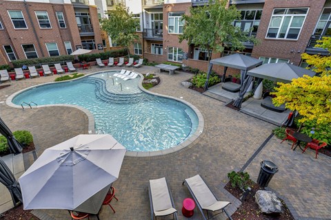 an aerial view of a swimming pool and patio with umbrellas
