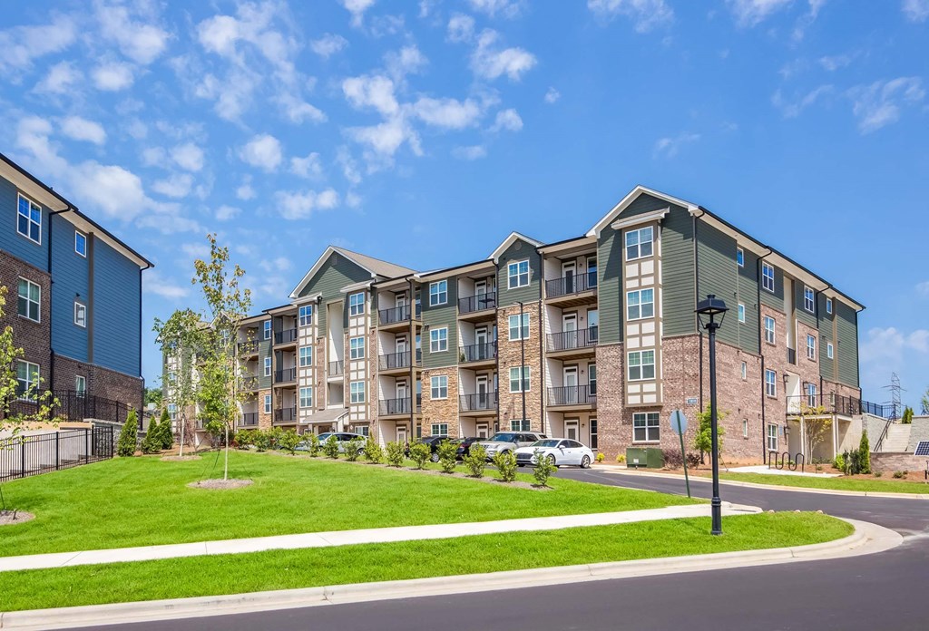 A large apartment complex with a grassy area in front.