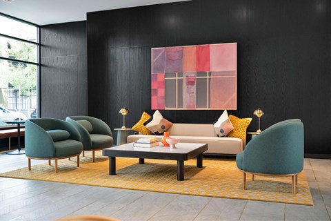 A living room with a large painting on the wall and a yellow rug on the floor.