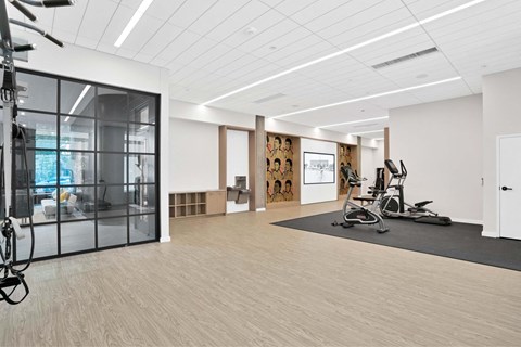 A gym with a treadmill, exercise bike, and weights.