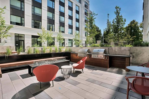 A patio with a table and chairs is in front of a building.