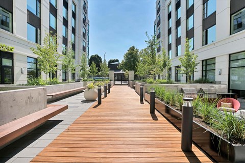 A wooden walkway leads between two buildings.