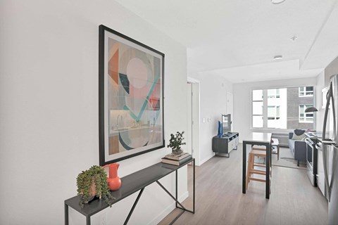 A modern living room with a large abstract painting on the wall.