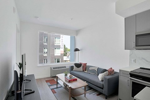 A living room with a grey couch and a coffee table.