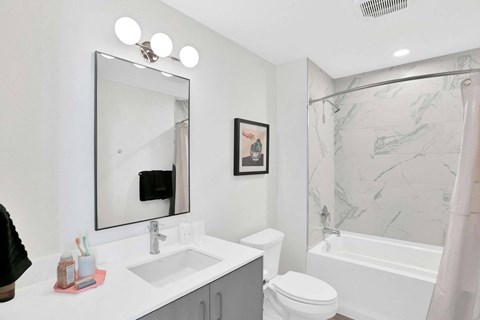 A bathroom with a white sink and a white toilet.