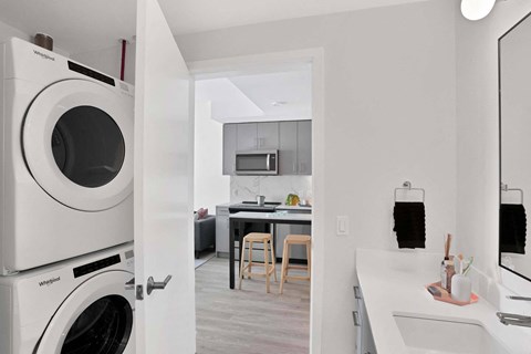 A white Whirlpool washing machine is in a kitchen.