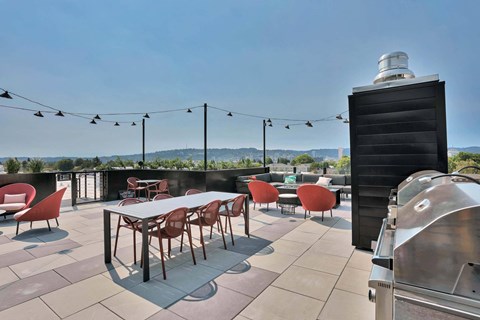 A rooftop patio with a table and chairs.