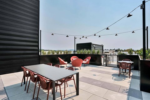 A patio with a table and chairs is set up on a rooftop.