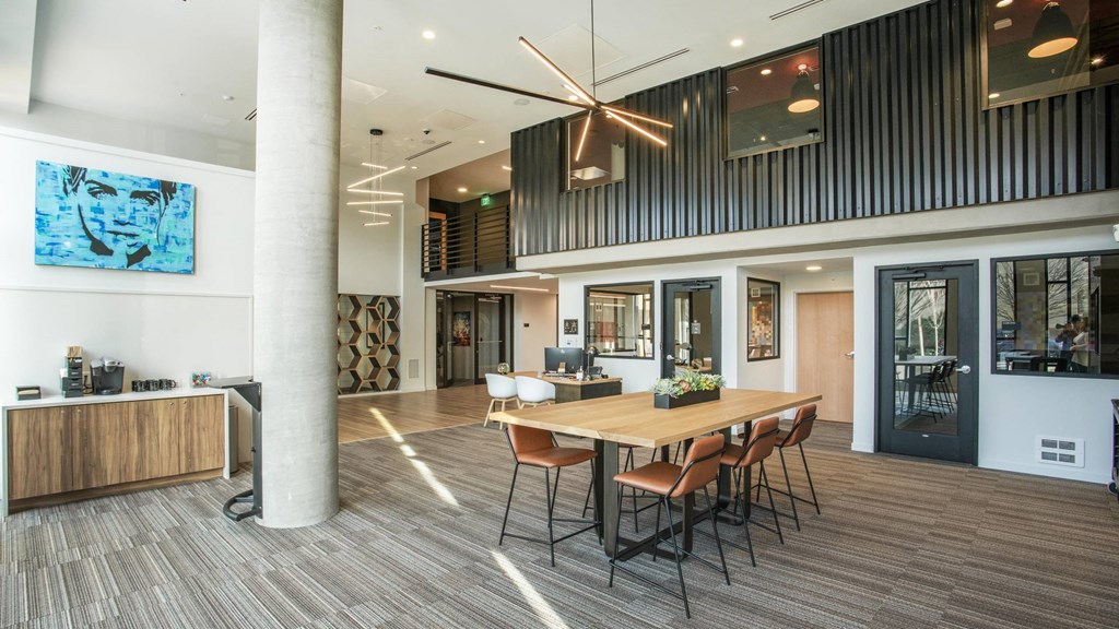 A modern office space with a long table and chairs, a ceiling fan, and a large painting on the wall.at Axle, Washington, 98119