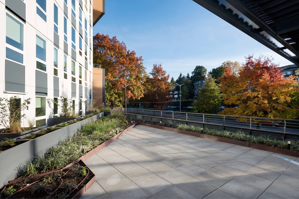 A modern building with a balcony and trees in the background.at Axle, Washington
