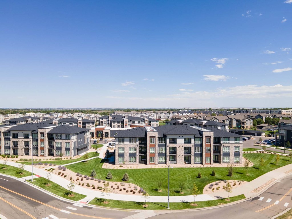 A large apartment complex with a grassy area in front.