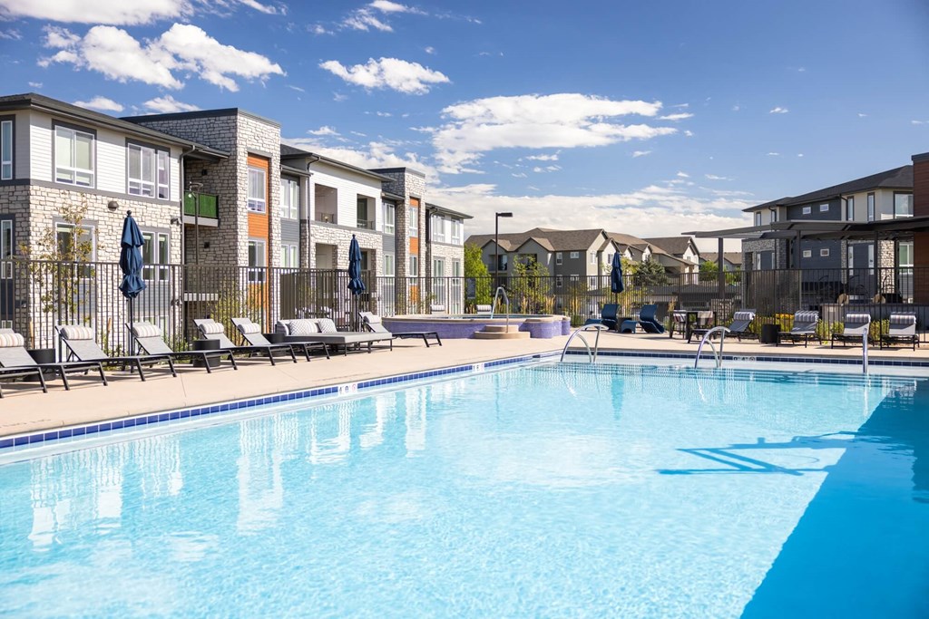 A swimming pool in front of apartment buildings.