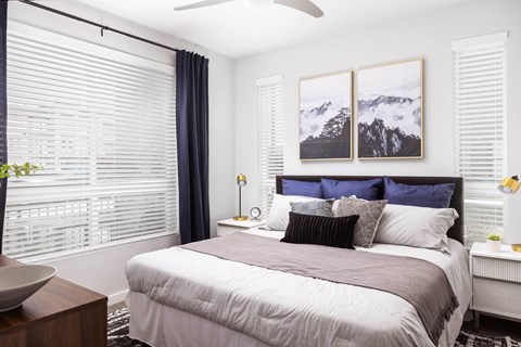 A bedroom with a large bed and a ceiling fan.