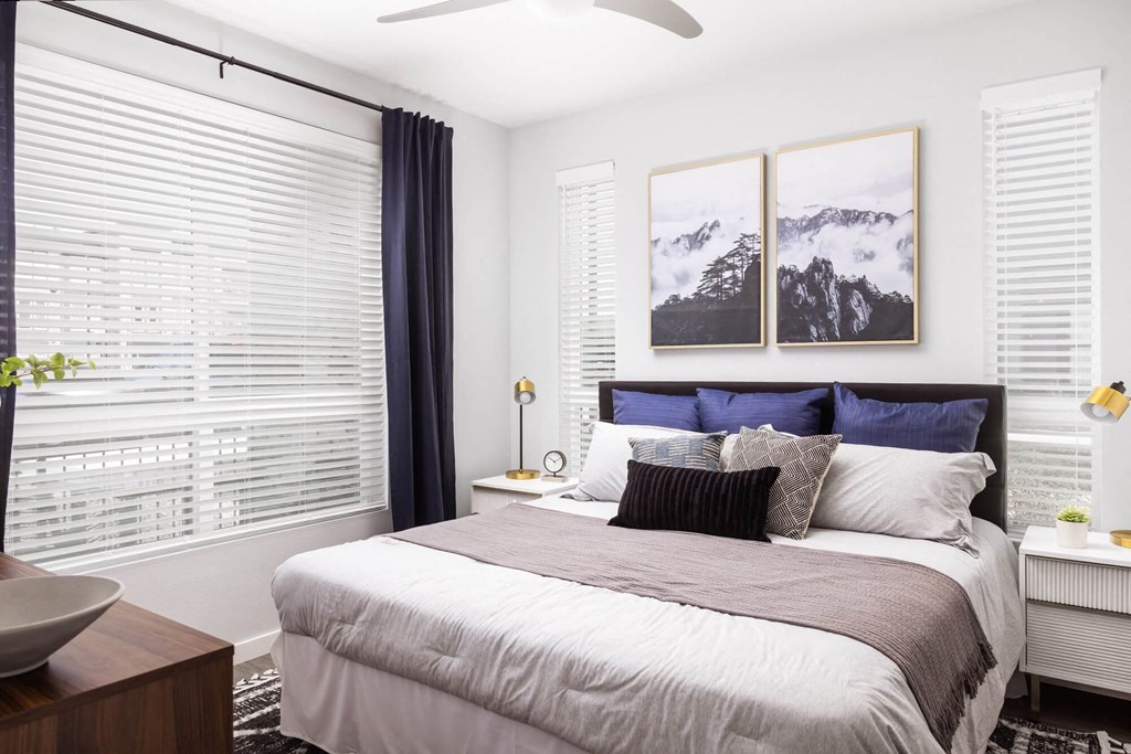 A bedroom with a large bed and a ceiling fan.
