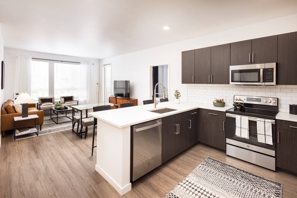 A modern kitchen with dark brown cabinets and stainless steel appliances.