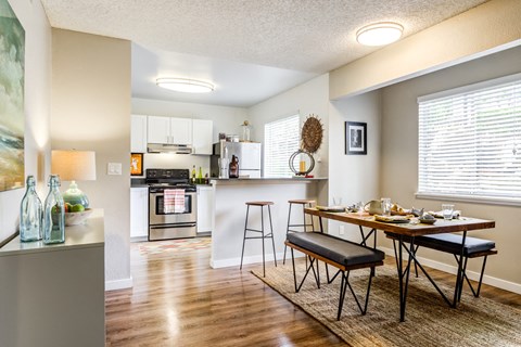 A kitchen with a table and chairs in front of it.