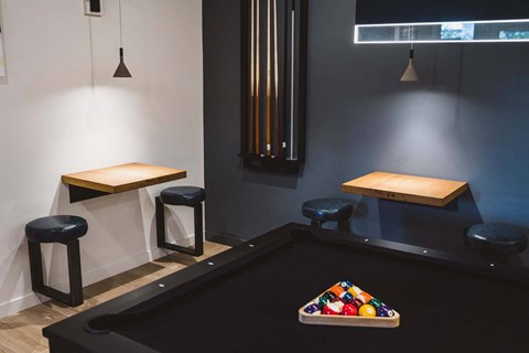 A pool table with a billiard ball triangle on it.
