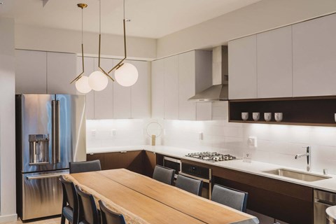 A modern kitchen with a wooden table and chairs.