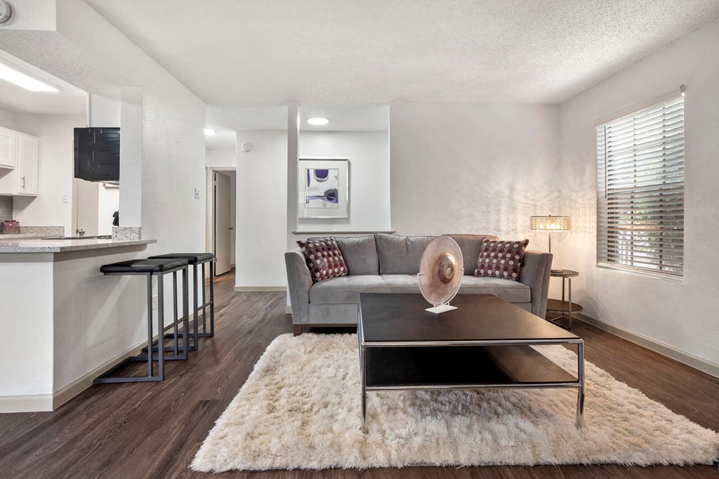 A modern living room with a grey couch and a coffee table.