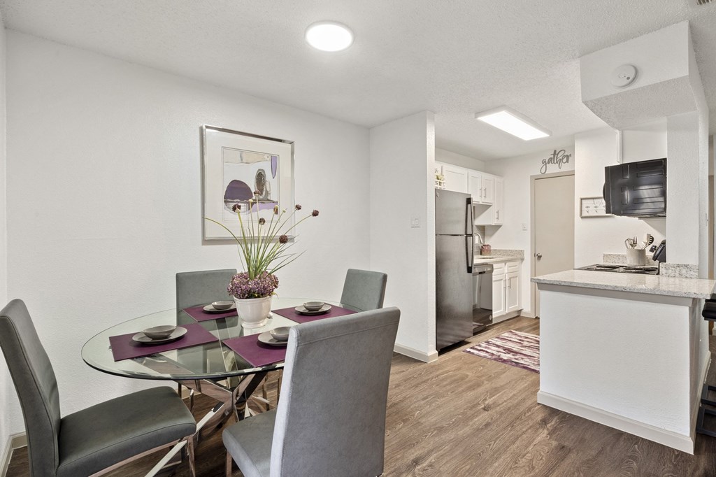 A modern dining room with a glass table and chairs.