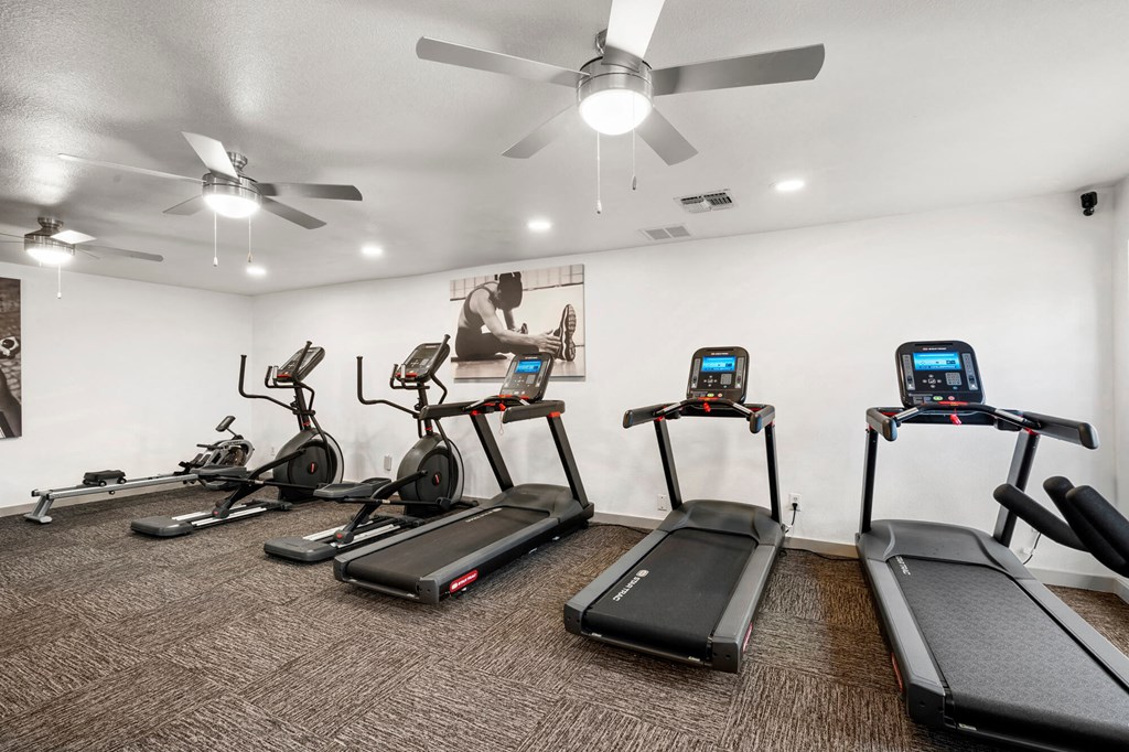 A gym with treadmills, exercise bikes, and elliptical machines.