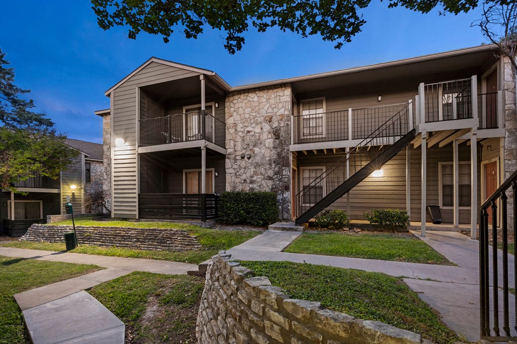 A modern two-story apartment building with a balcony on the second floor.