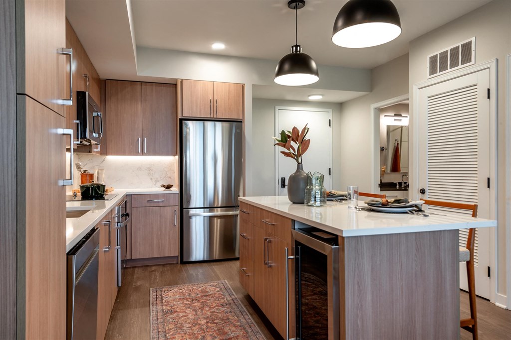 A modern kitchen with a refrigerator, sink, and cabinets.