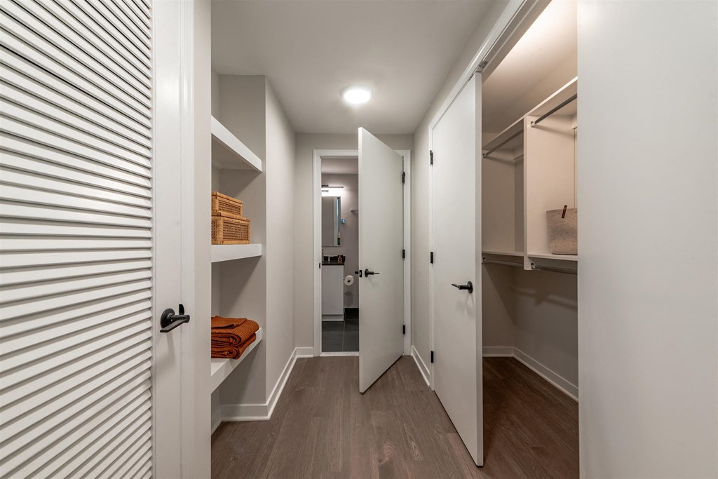 A hallway with a white door on the left and a white door on the right.