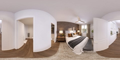 A bedroom with a large bed and a ceiling fan.