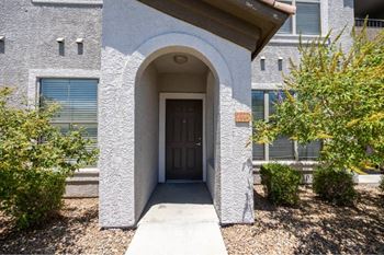 A house with a brown door and a small garden in front.