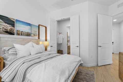 A bedroom with a large bed and a painting on the wall.