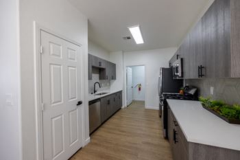 A kitchen with a white door and a black fridge.