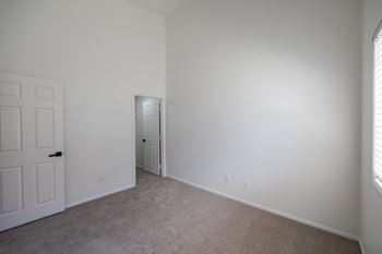 A room with a carpeted floor and a white door.