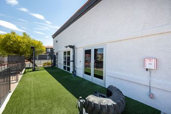 A white building with a tire in front of it.